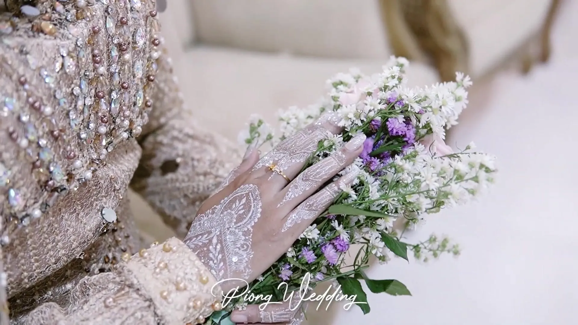 Tangan pengantin dengan henna putih memegang buket bunga