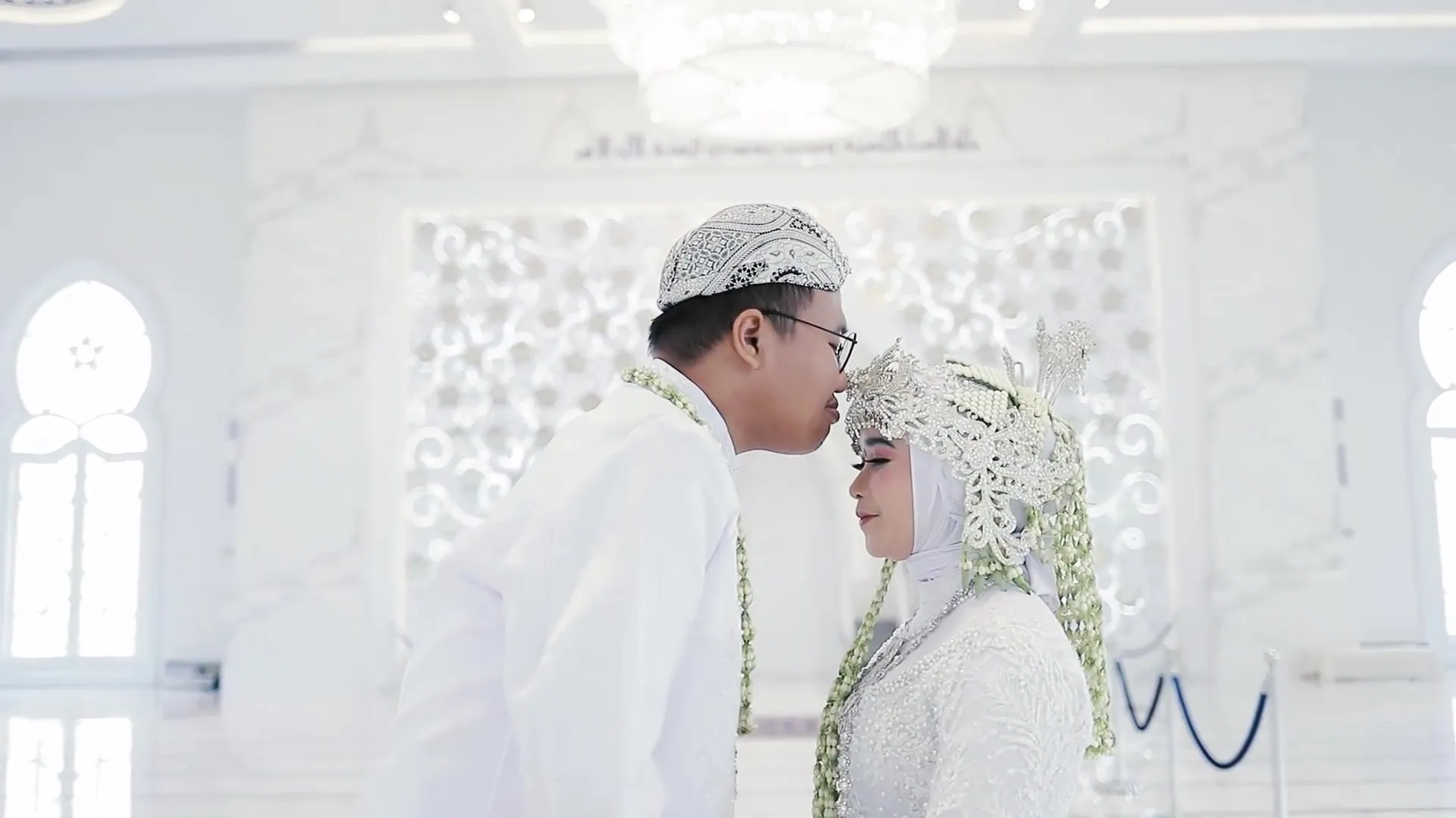 Pengantin laki-laki mengecup kening istrinya setelah akad